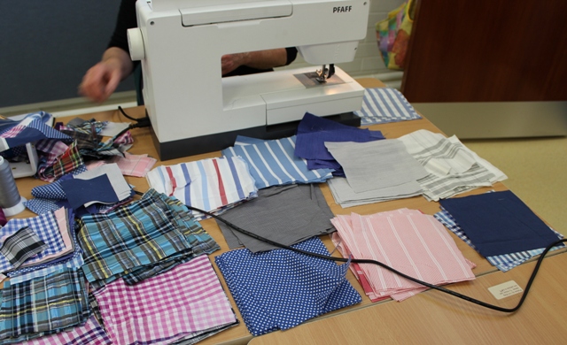 Beres cut out squares from men's shirts ready to piece into a quilt
